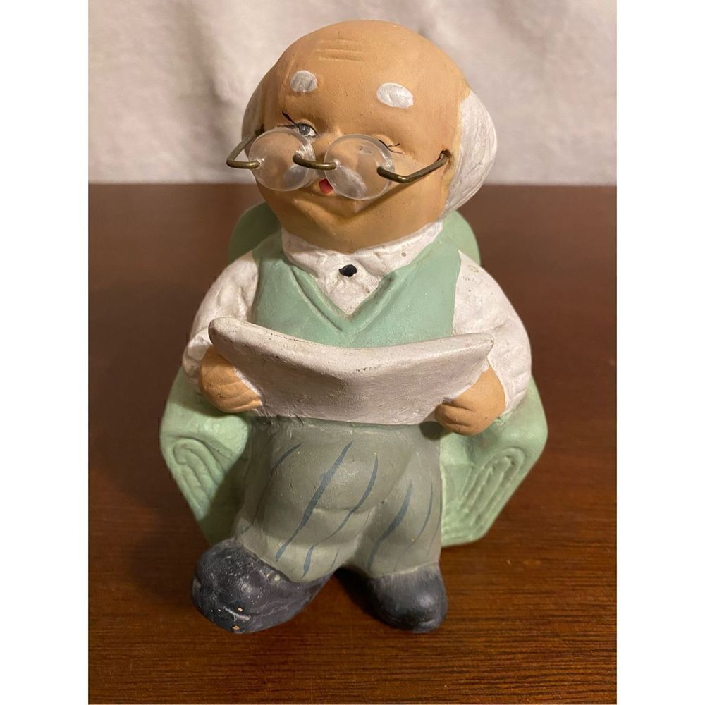 Vintage grandpa sitting in easy chair reading newspaper glass bank